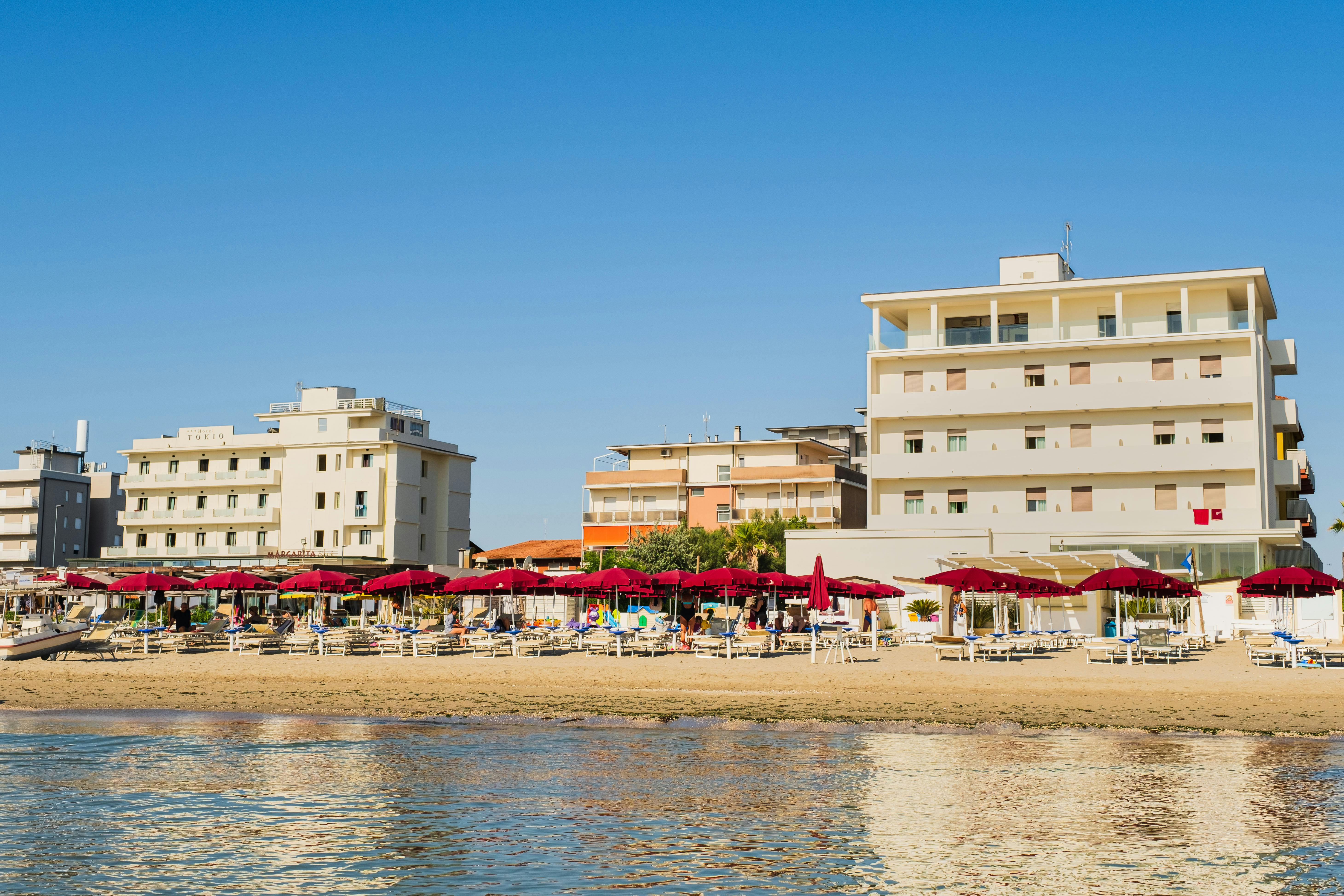 beach is lined with sun loungers and umbrellas