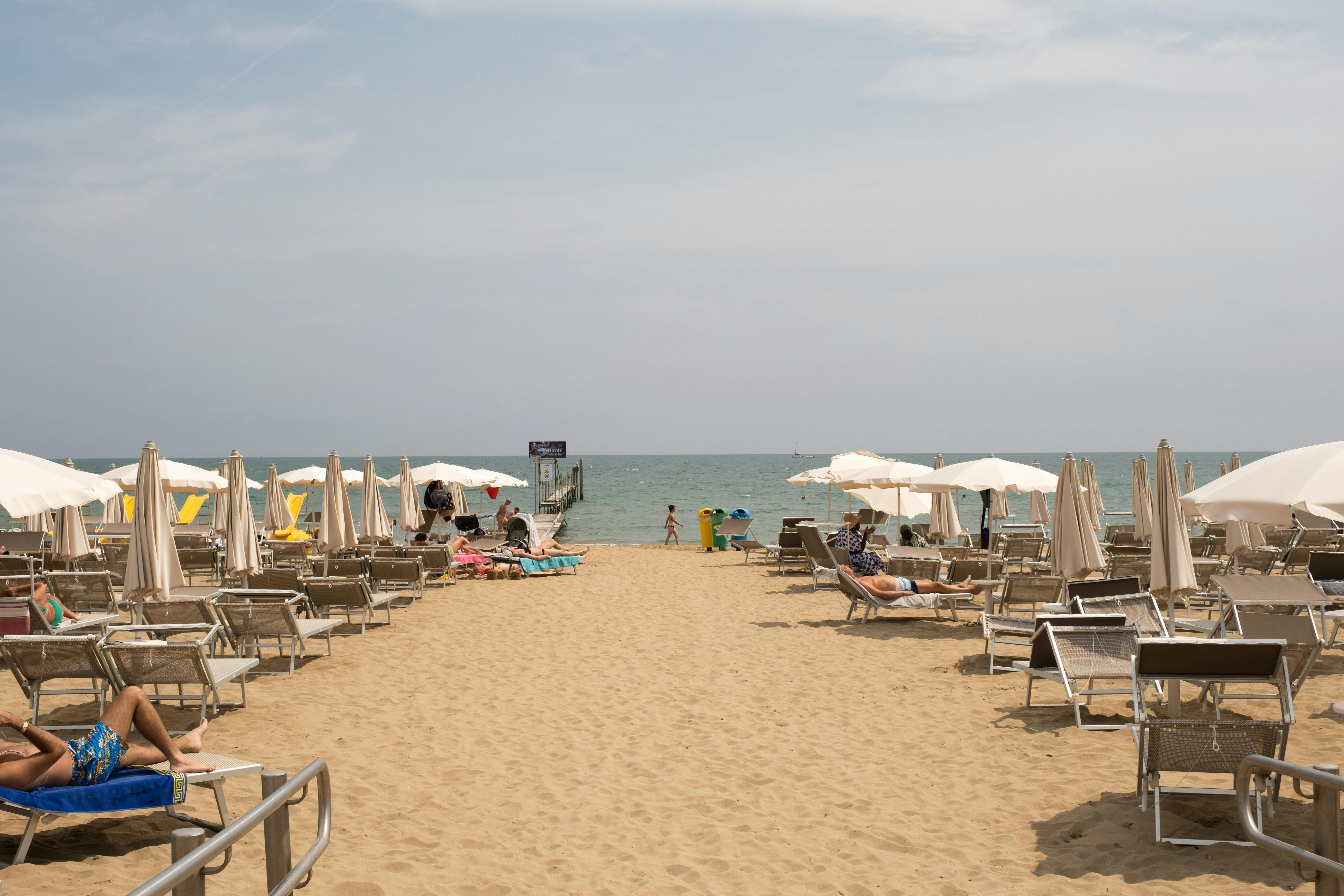 tourists sunbathing on sun loungers set on the beach