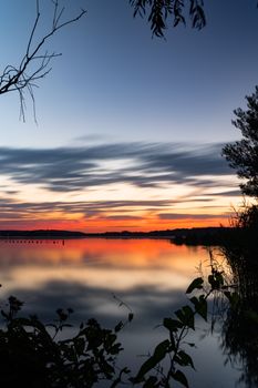 A serene lakeside sunset in Potsdam with colorful reflections and scenic views.
