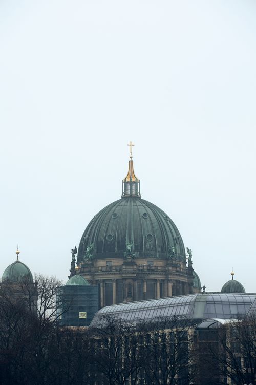 Free Vertical shot of the Berlin Cathedral's iconic dome under an overcast sky, capturing its architectural grandeur. Stock Photo