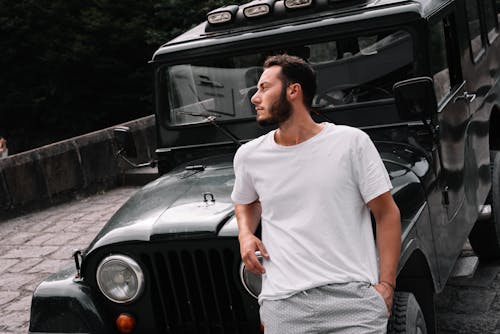 Man in T-shirt by Jeep Car