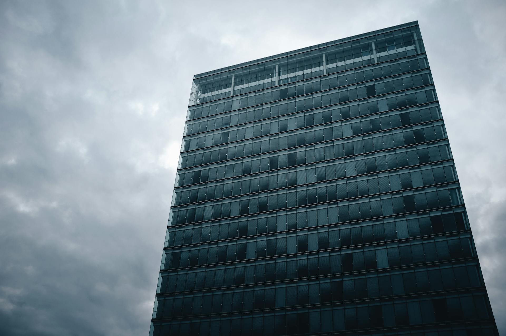 A sleek modern skyscraper under a cloudy sky in Luxembourg City.