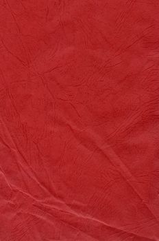 Close-up of a vibrant red fabric texture with detailed creases, perfect for design projects.