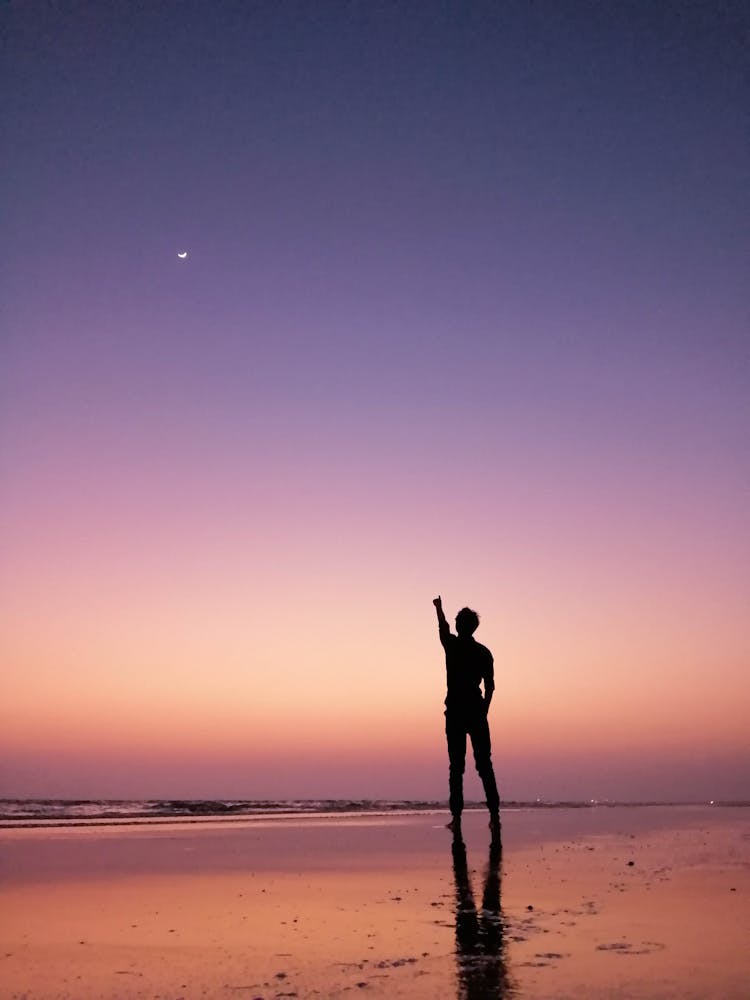 Silhouette Of Man Pointing At Star During Sunset 