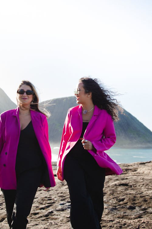 Smiling Women in Pink Jackets on Beach