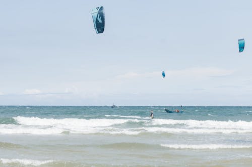 People Kitesurfing on Waves