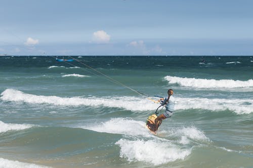 Woman Kitesurfing on Waves on Sea Shore