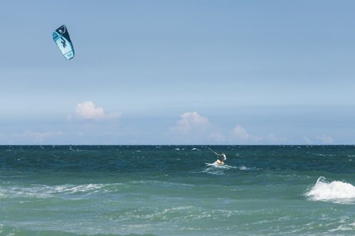 Free Experience the thrill of kitesurfing on a sunny day at the beach, perfect for adventure enthusiasts. Stock Photo