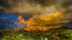 在动态云层下，巴基斯坦卡拉姆戏剧性的山地景观中出现了彩虹