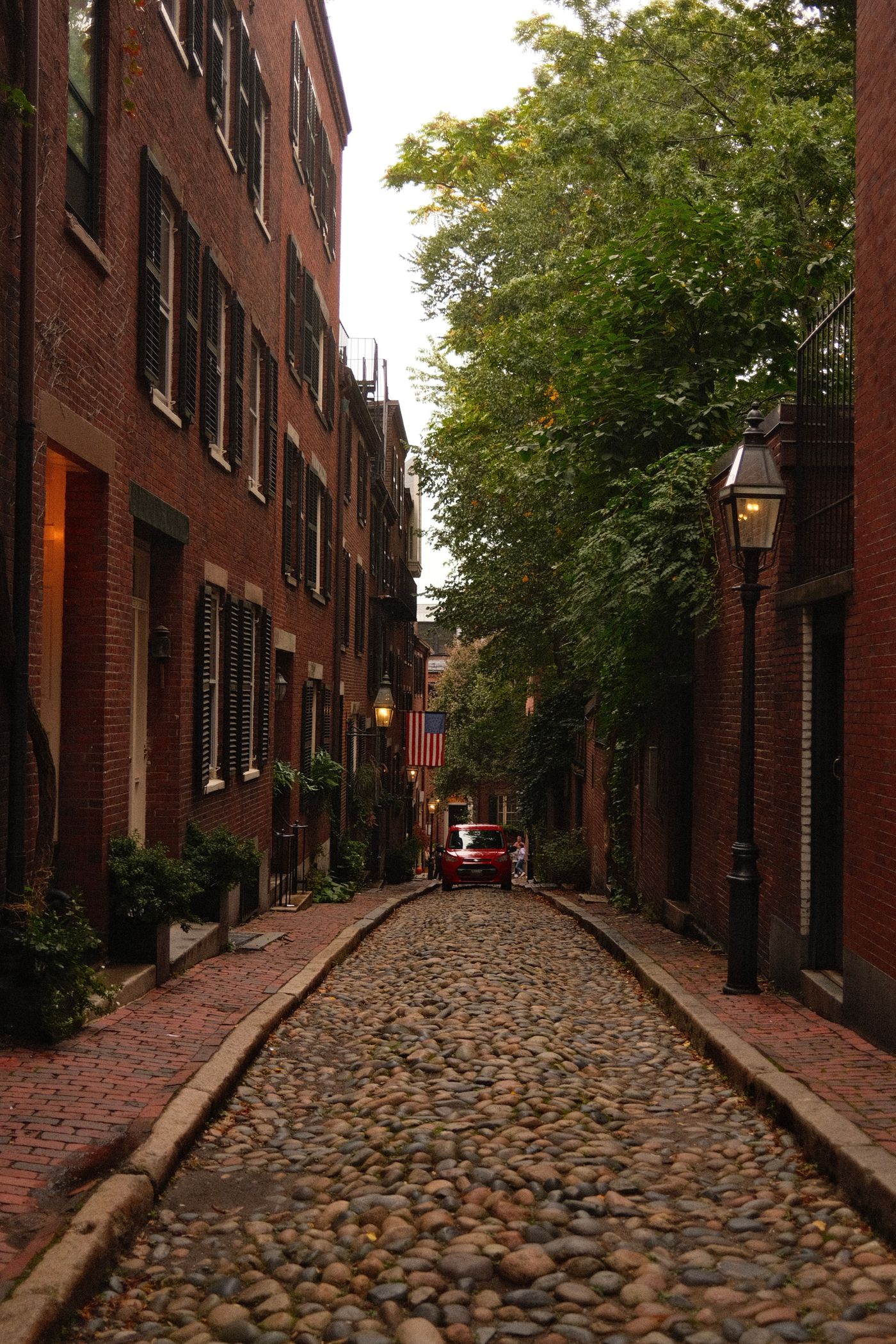 A narrow cobblestone street between brick buildings