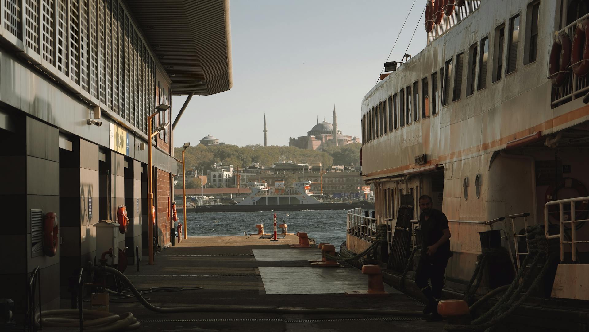 A scenic view of Istanbul's ferry terminal with Hagia Sophia in the backdrop, capturing a blend of urban life and historical architecture.