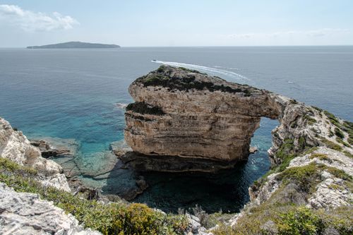 Free Stunning rock arch formation along the coastline of Paxos, Greece. Stock Photo