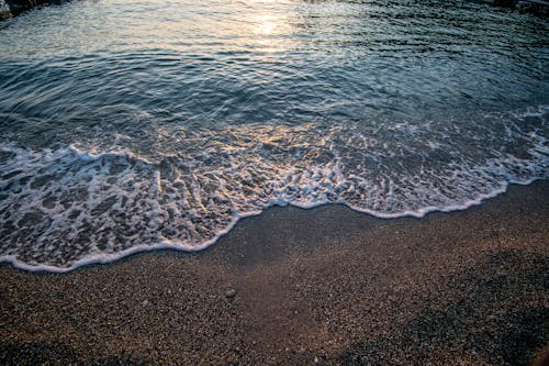 Sunlight on Water on Shore at Sunset