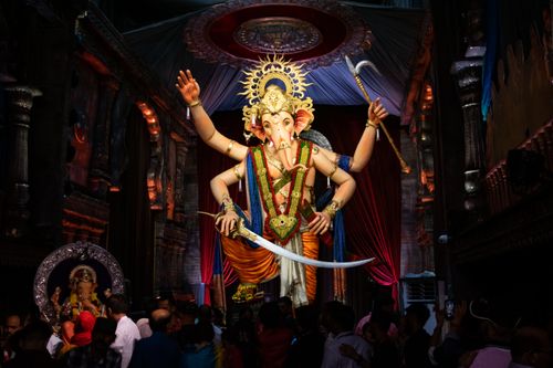 Free Colorful Ganesh idol surrounded by devotees during Ganesh Chaturthi festivities in Mumbai. Stock Photo