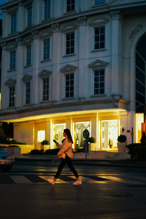 Free Woman walking across a city street at night in Ankara, Türkiye. Stock Photo