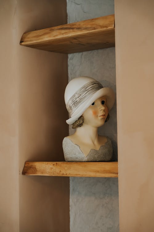 A Figurine of a Girl Standing on a Wooden Shelf