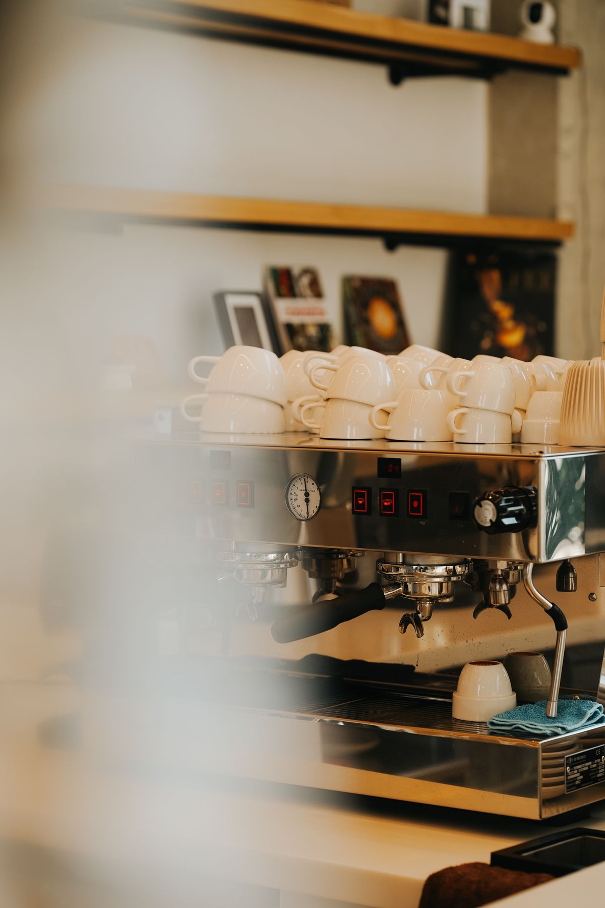 Espresso machine with cups stacked in a cafe setting, for illustration