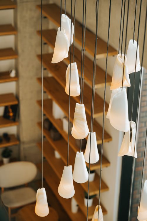 Free Stylish hanging lights and wooden shelves in a modern Ankara interior. Stock Photo