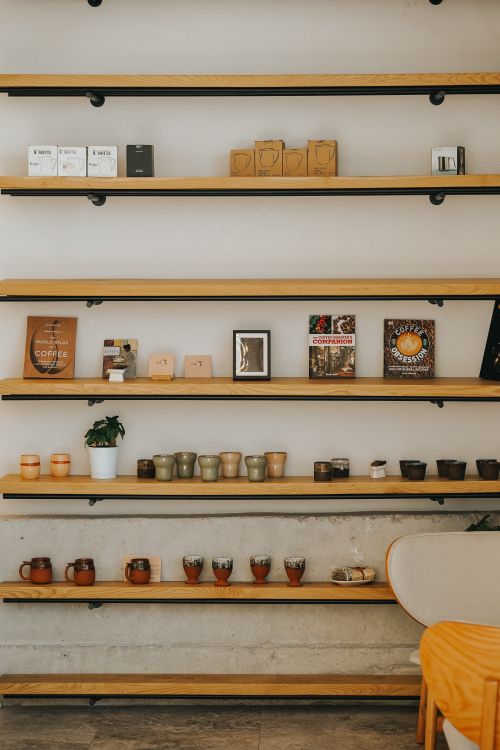 Free Elegant shelving unit in Ankara with ceramics, books, and decor items, creating a warm indoor ambiance. Stock Photo