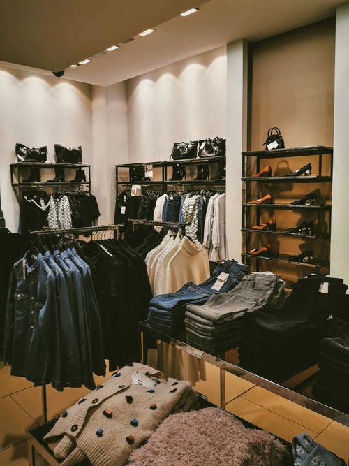 Free Stylish clothing store interior featuring a modern display of apparel and accessories. Stock Photo