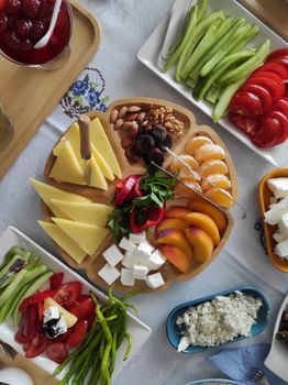 Vibrant platter of cheeses, fruits, and vegetables for a fresh meal setting.