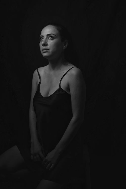 Free A contemplative woman gazes upward in this moody, black and white portrait. Stock Photo