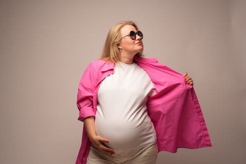 Blonde Pregnant Woman in Pink Jacket
