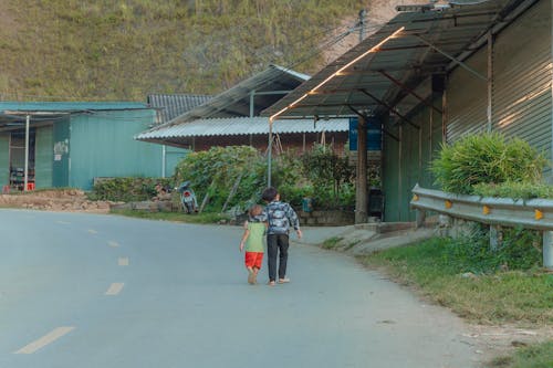 Boys Walking Together on Road in Village