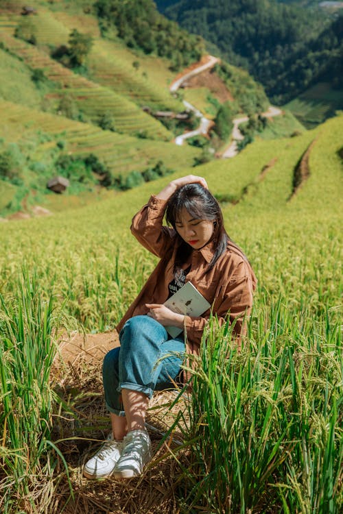 Kostnadsfri bild av asiatisk kvinna, bok, fält