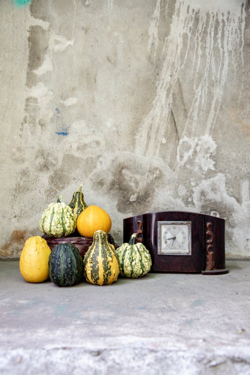 Pumpkins and Wooden Clock on Concrete