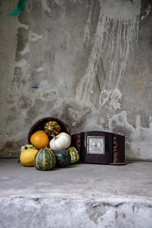 Antique Clock and a Pile of Winter Squashes Spilled from a Wicker Basket