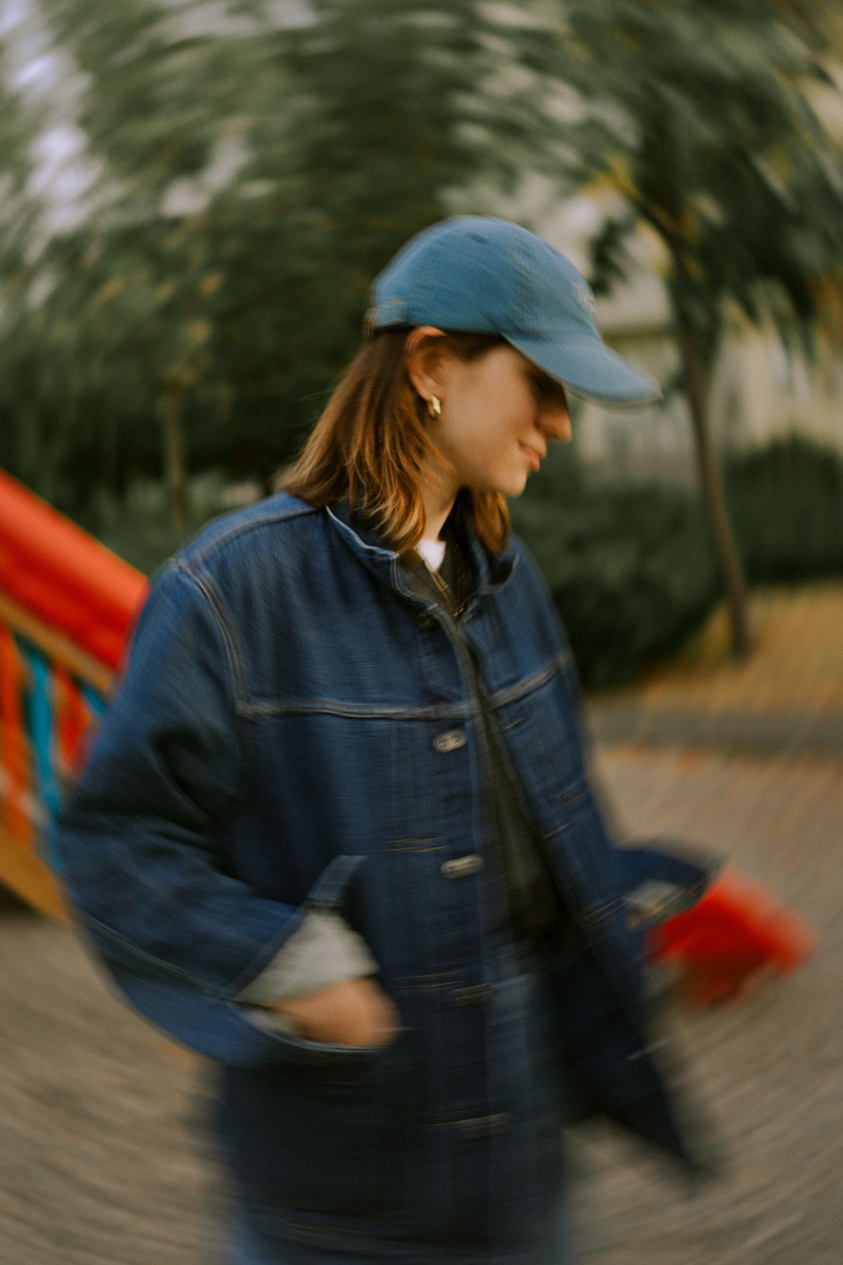 A woman in a cap and jean jacket — the structured trucker