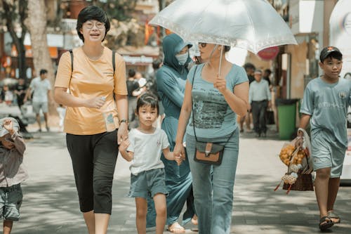 Two Women and a Girl Walking Together in a City 