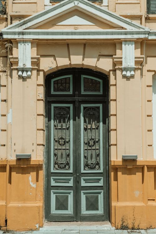 Free Captivating traditional facade with an ornate entrance and vintage architectural details. Stock Photo