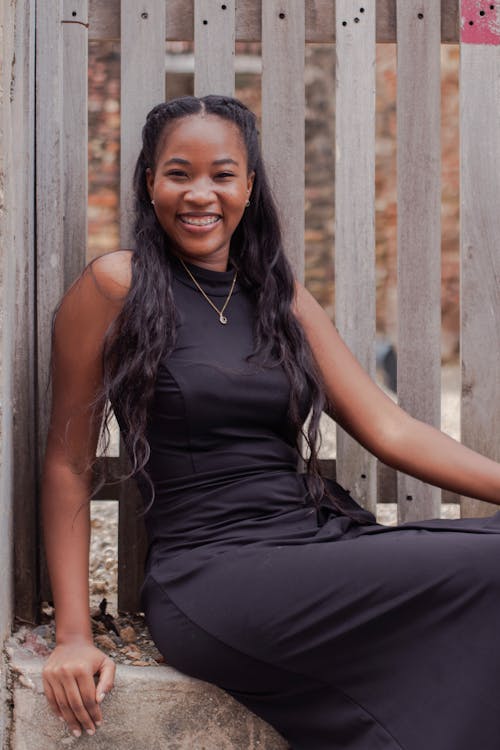 Young Elegant Woman Sitting Outside and Smiling 