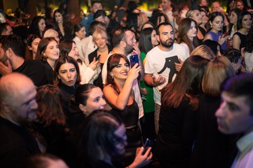 Free A lively crowd enjoys a night of music and fun, capturing the moments on smartphones. Stock Photo
