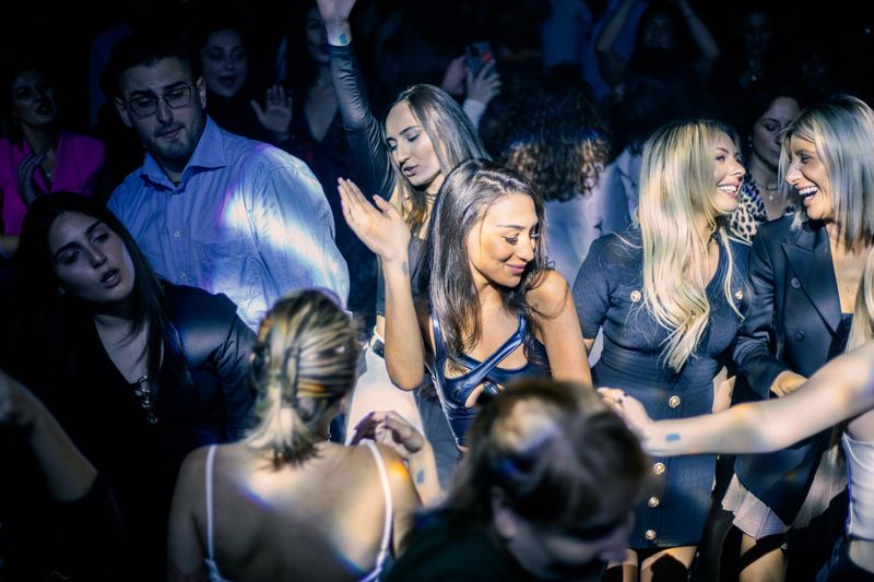 Guests dancing with hands raised at a disco night