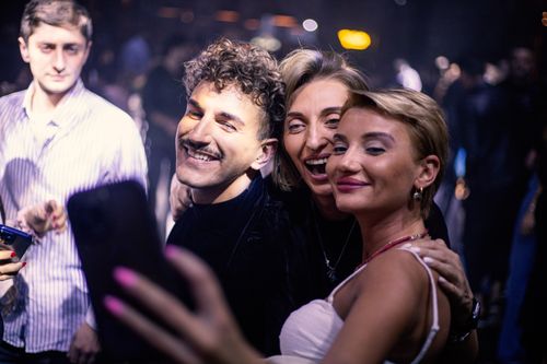 Free Cheerful friends taking a selfie at a vibrant nightclub party, capturing the joy of the moment. Stock Photo