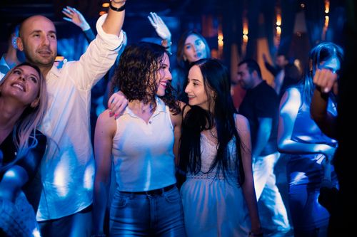 Free Young adults dancing and enjoying a lively night at a vibrant nightclub. Stock Photo