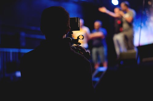 Homme Debout Sur Scène Tenant Un Microphone