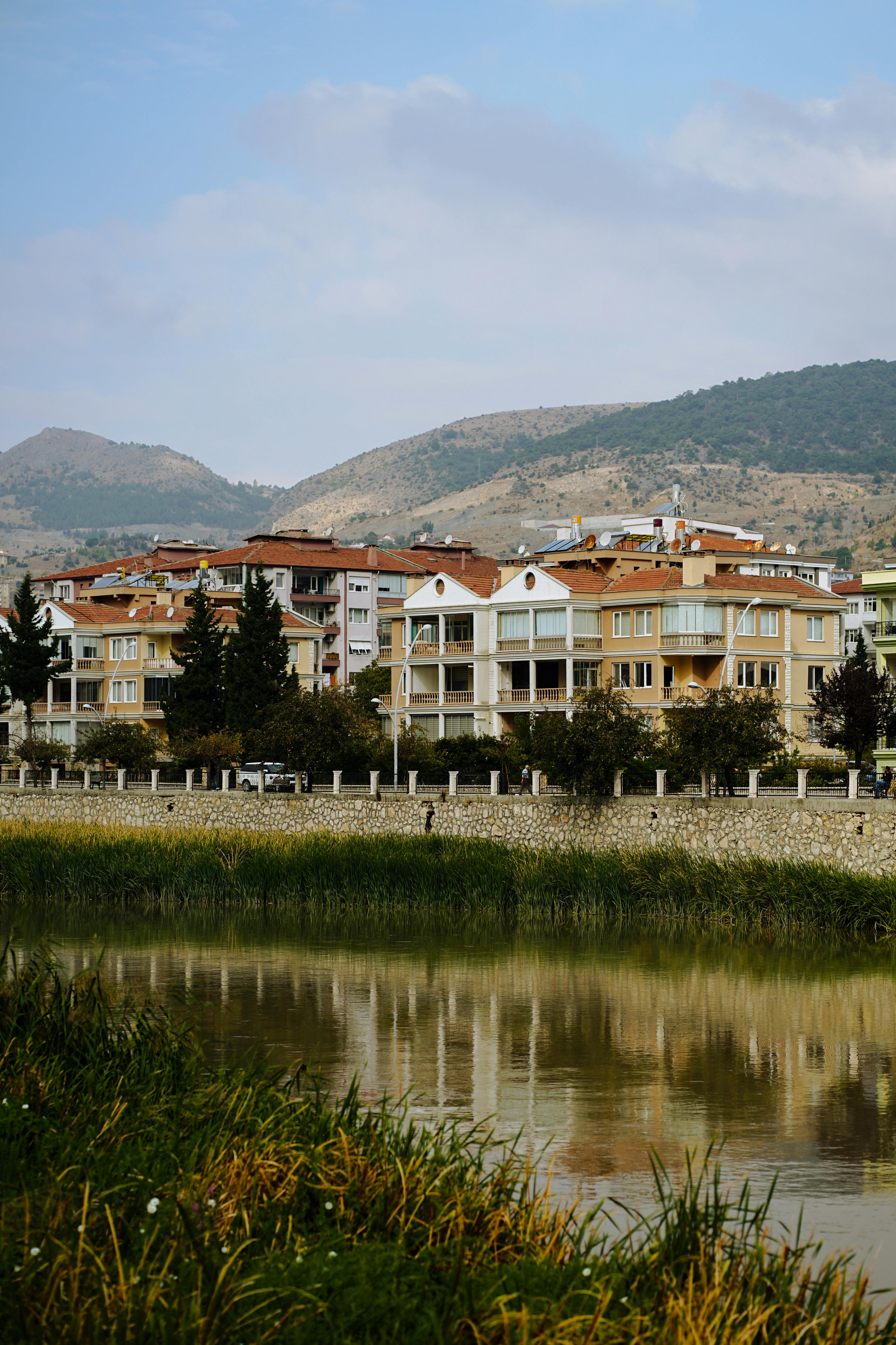 Scenic view of buildings along the river in Amasya, Turkey, with mountainous backdrop.