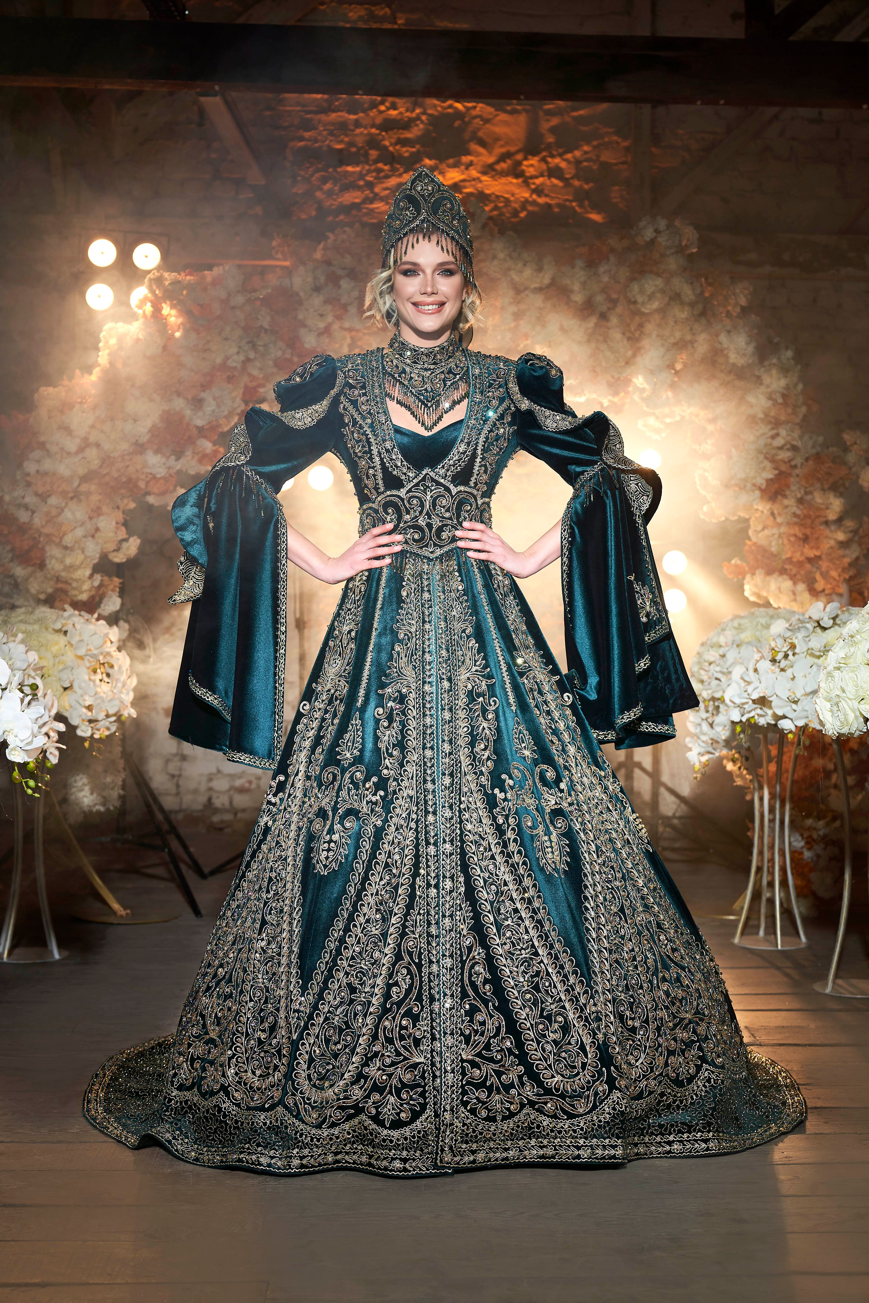 Woman in ornate traditional dress poses in İzmir studio setting