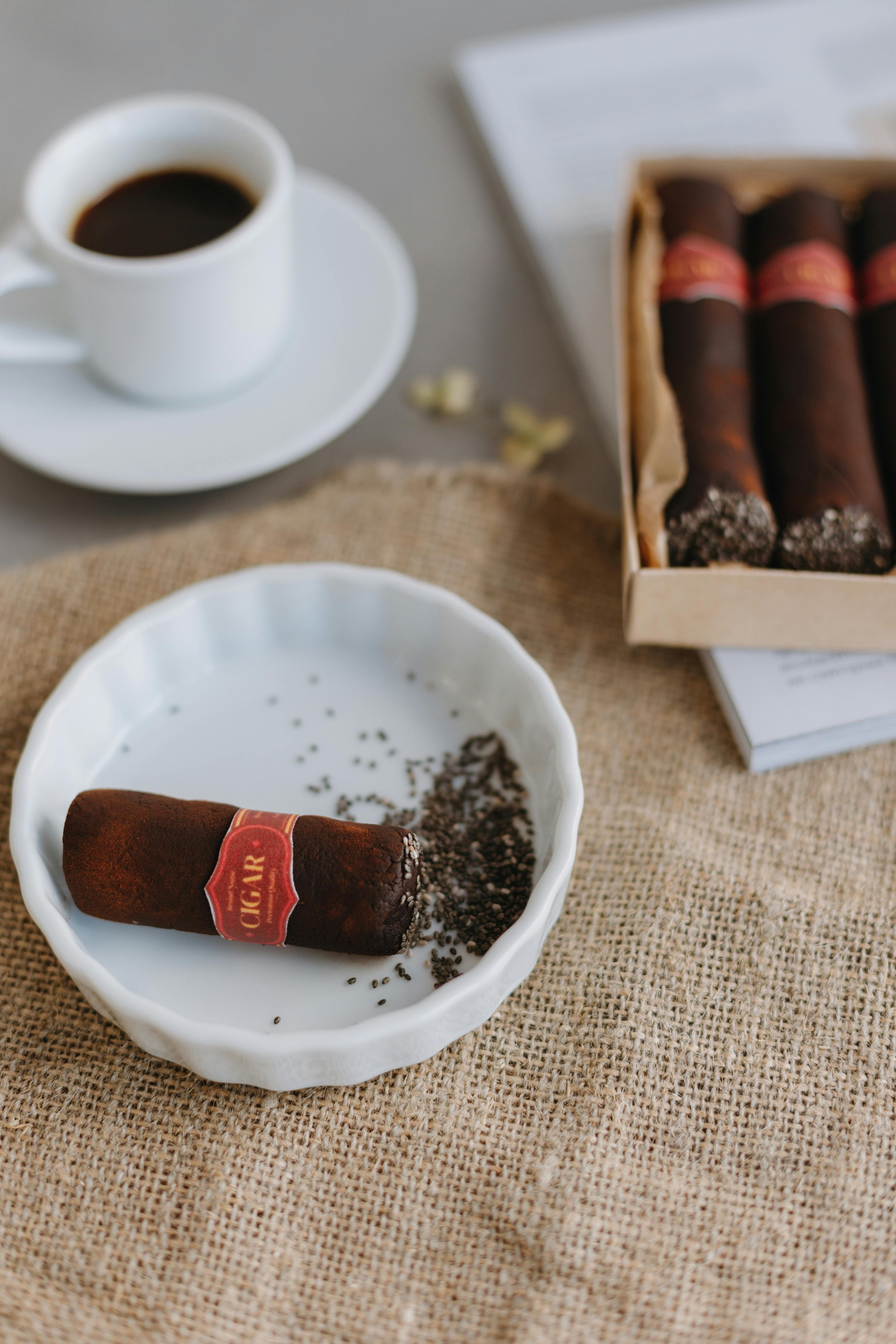 A classic pairing of espresso and cigars arranged on a natural burlap surface for an elegant presentation.