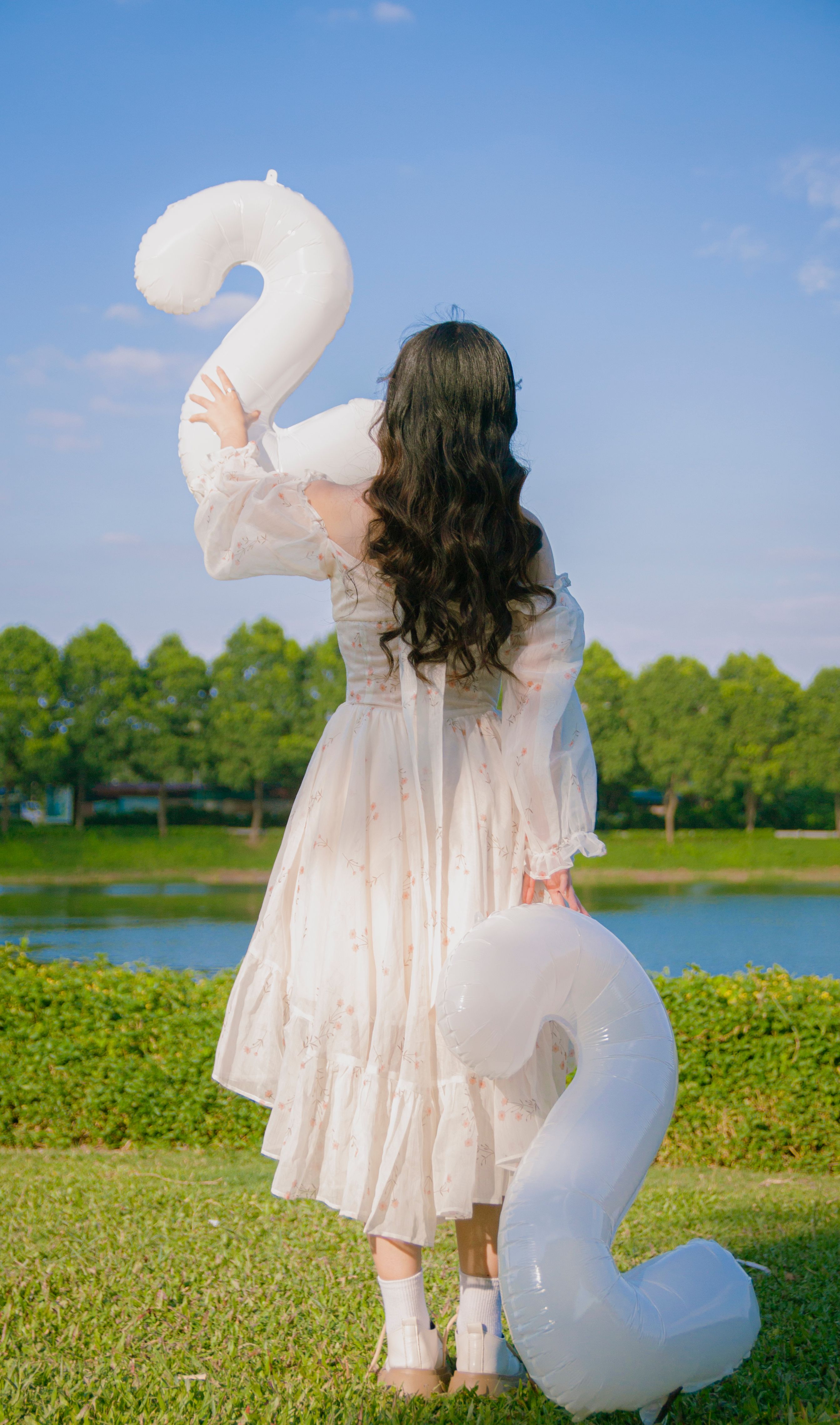Woman in White Dress Standing with Birthday Balloons  Free Stock Photo