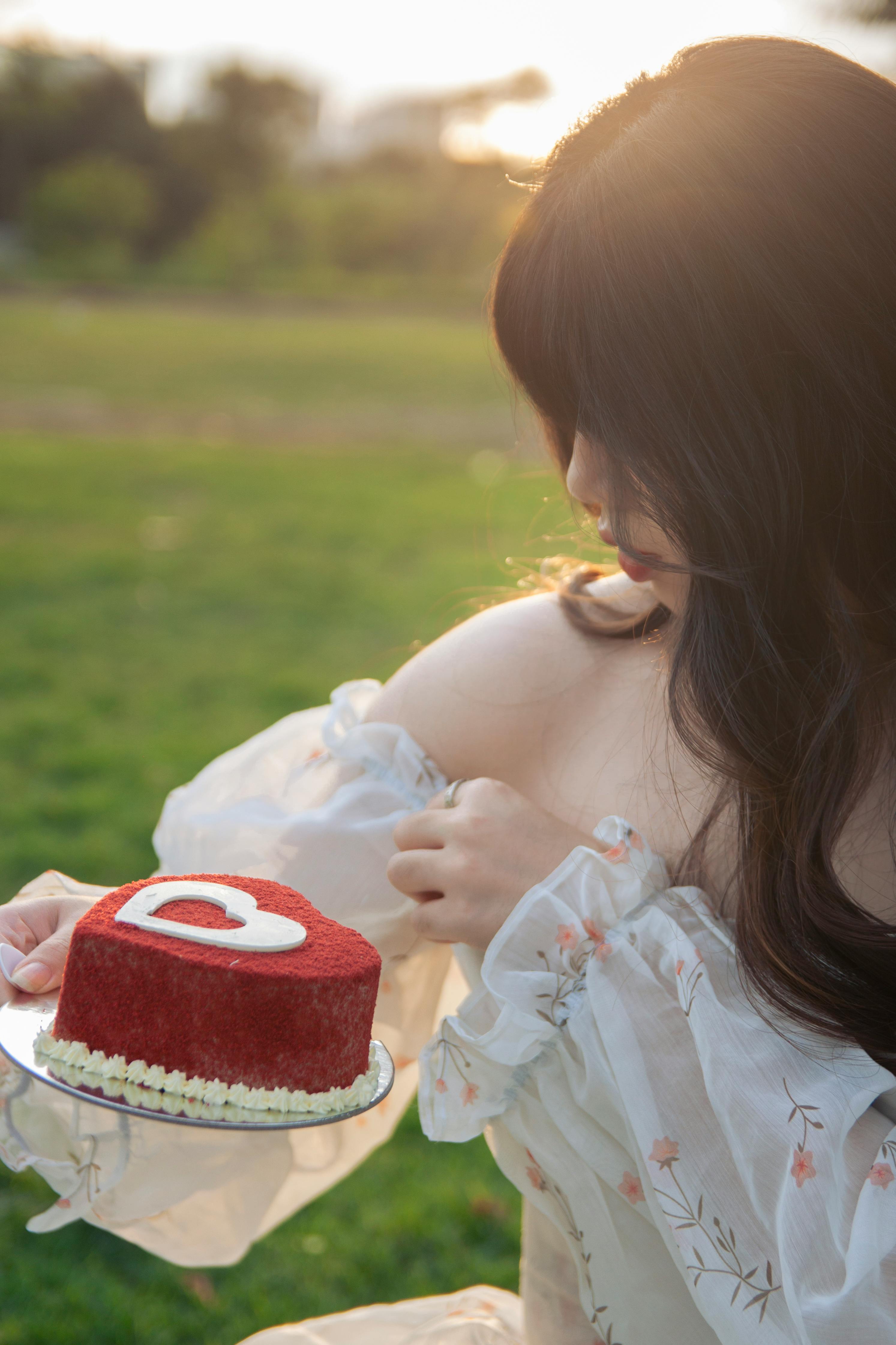 Woman with Black Hair Holding Cake with Heart · Free Stock Photo