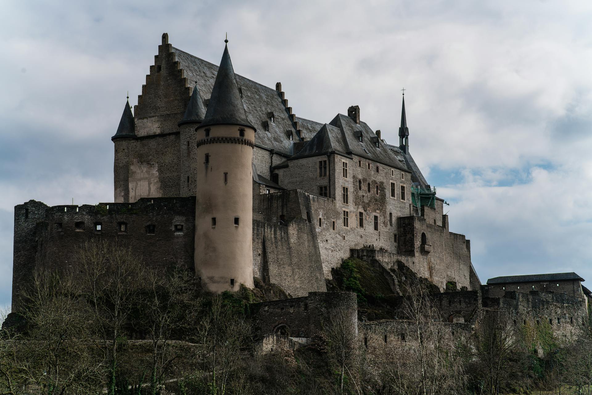 Historic Vianden Castle in Luxembourg captures medieval architecture against a cloudy sky.