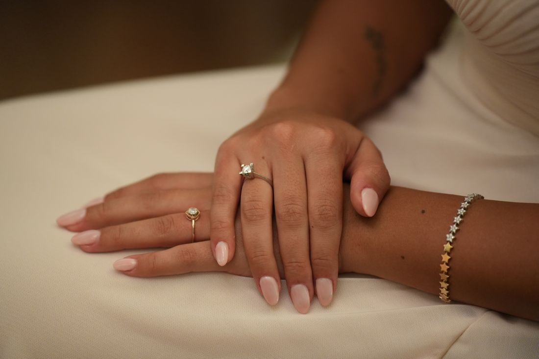 A pair of softly manicured hands resting, warm neutral tones