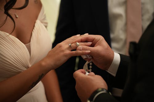 Groom Putting a Wedding Ring on Bride Finger