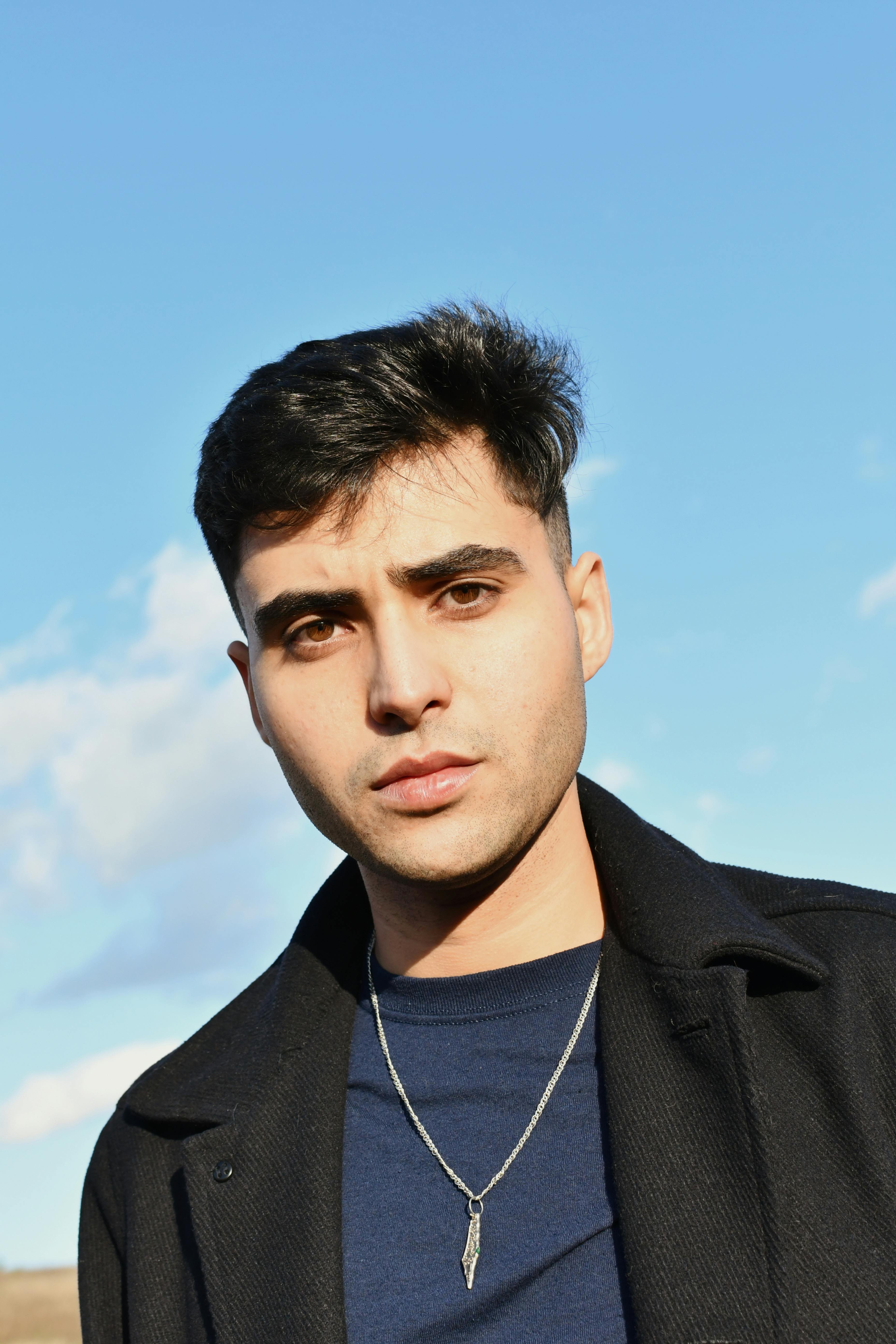 free photo of portrait of handsome young man posing against blue sky