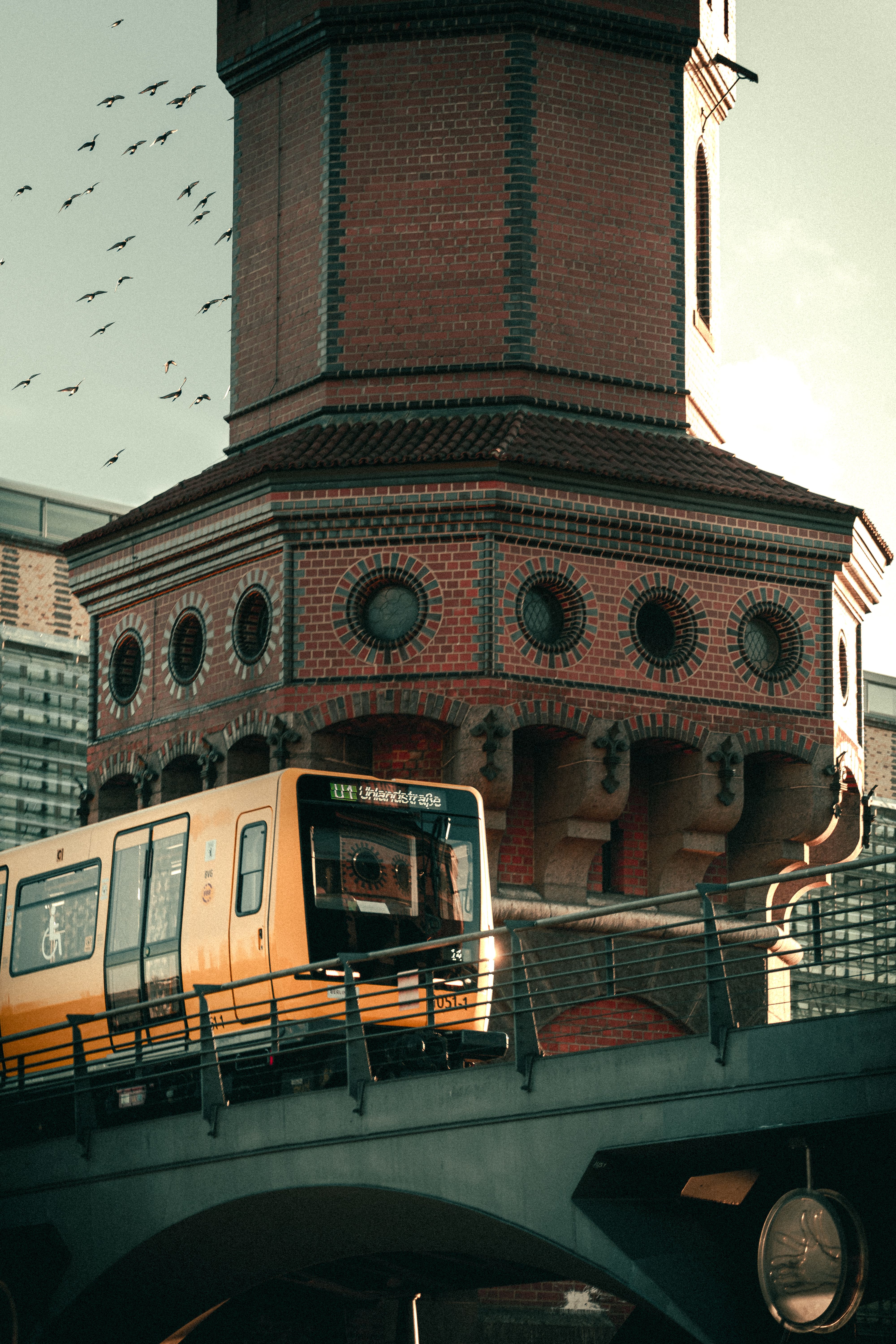 Yellow train crossing Oberbaum Bridge in Berlin, showcasing urban architecture.
